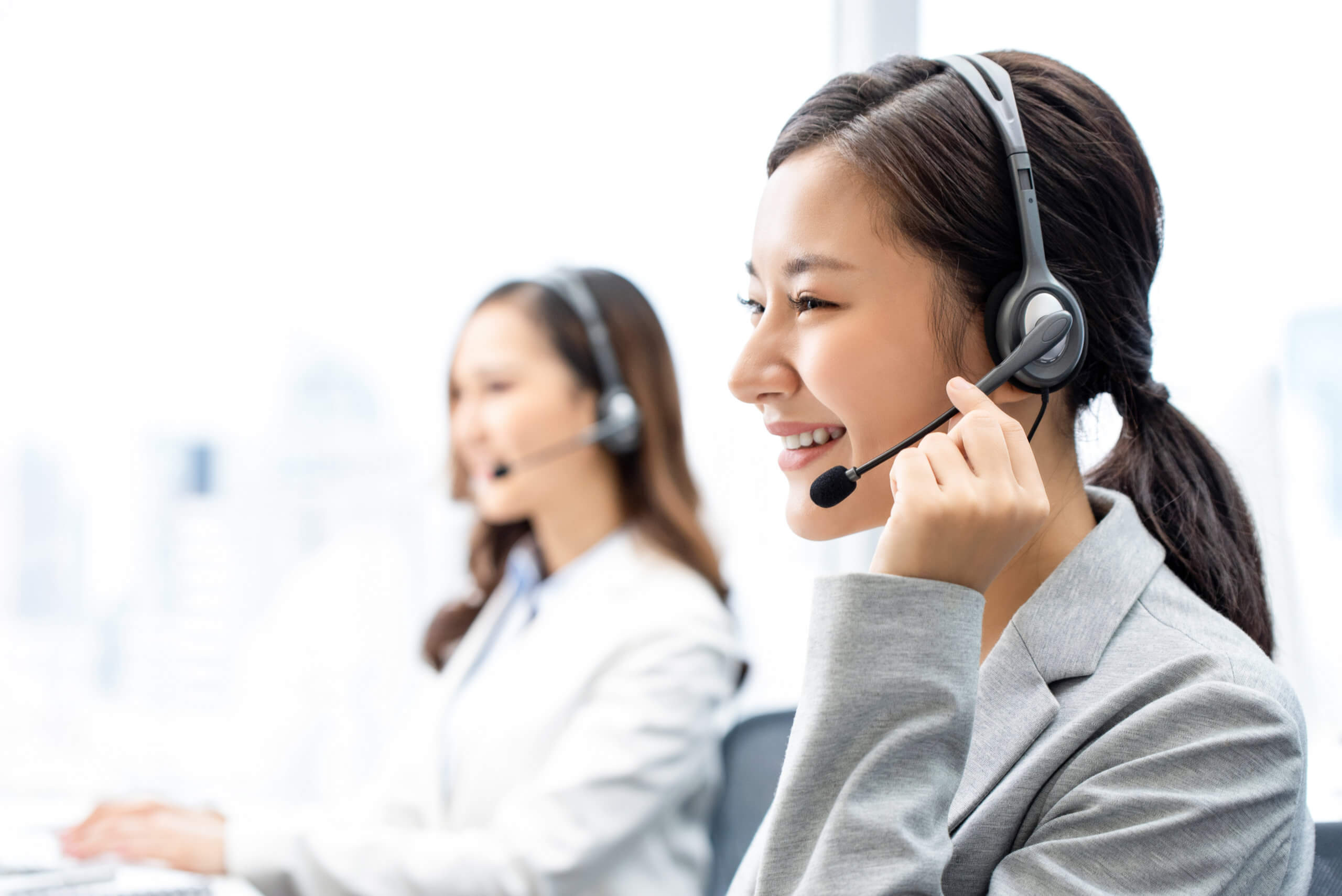 Smiling,Telemarketing,Asian,Woman,Working,In,Call,Center,Office Woman with Headphones in Call Center Smiling