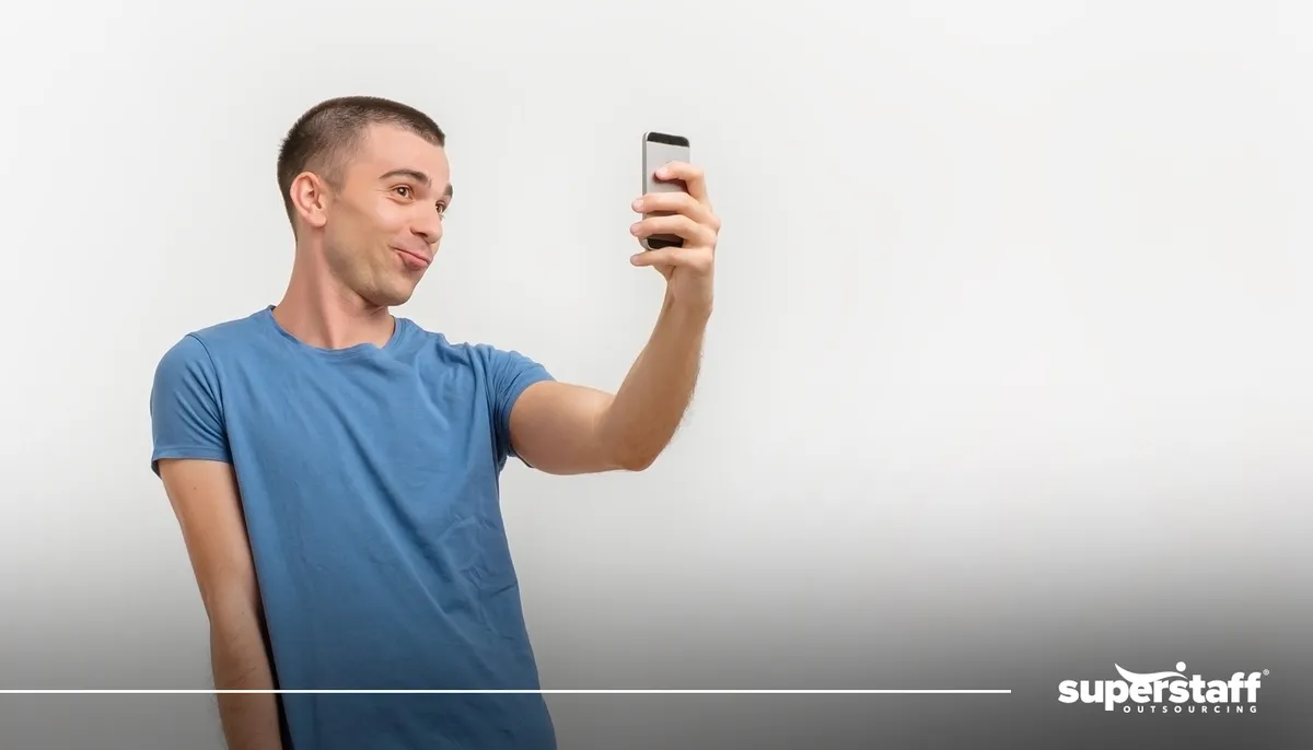 A photo shows a man coyly taking a selfie.